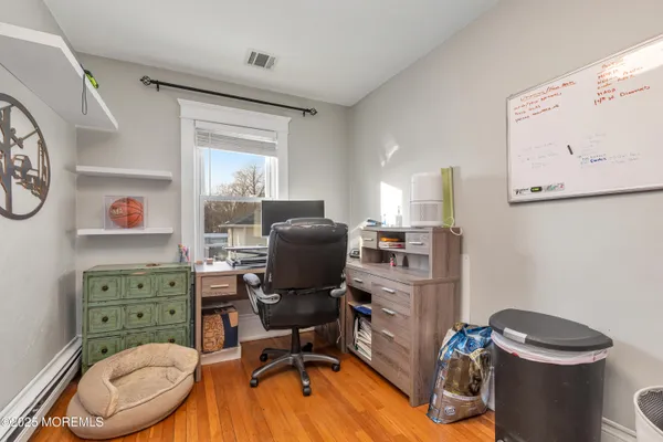 a view of a workspace with furniture and a window