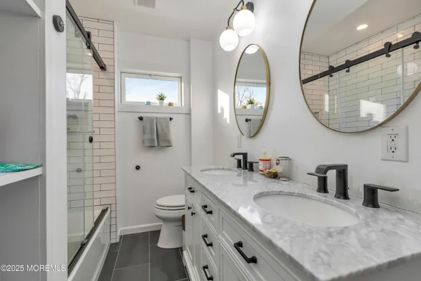 a bathroom with a granite countertop sink a toilet and a mirror