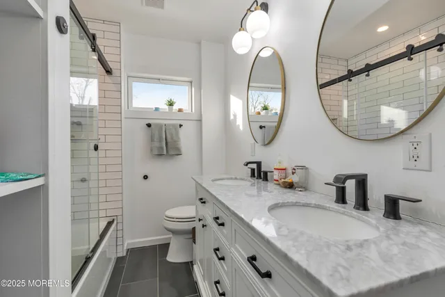 a bathroom with a granite countertop sink a toilet and a mirror