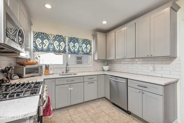 a kitchen with stainless steel appliances granite countertop a sink stove and cabinets