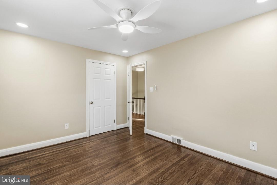 5102 Plymouth Road Baltimore, MD 21214 - Photo 15 of 32 a view of an empty room with wooden floor and a ceiling fan
