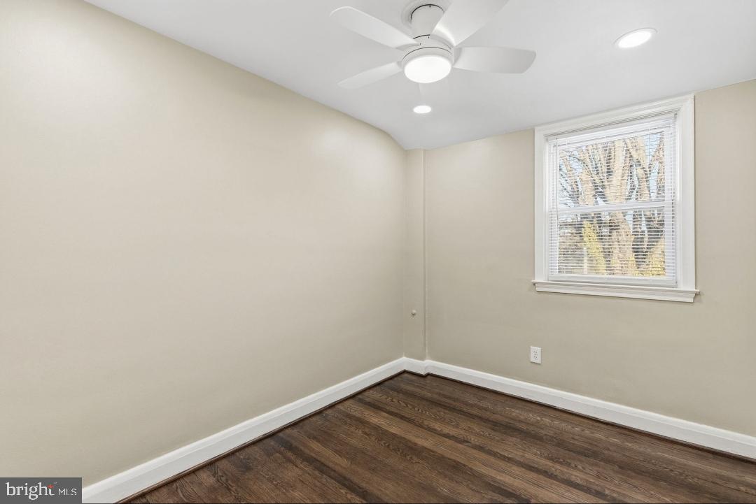 5102 Plymouth Road Baltimore, MD 21214 - Photo 16 of 32 an empty room with a window and wooden floor