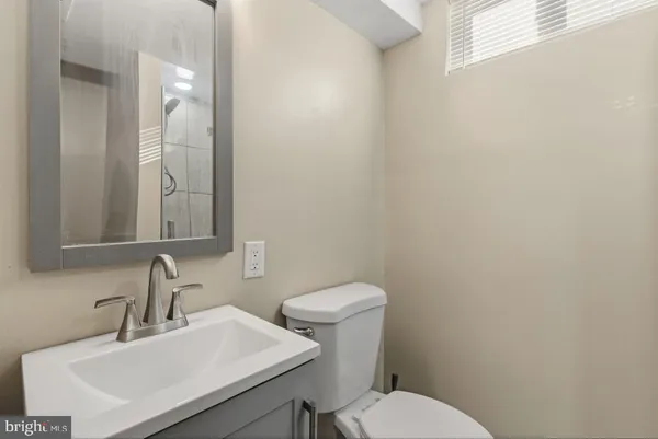 a bathroom with a sink a toilet and mirror