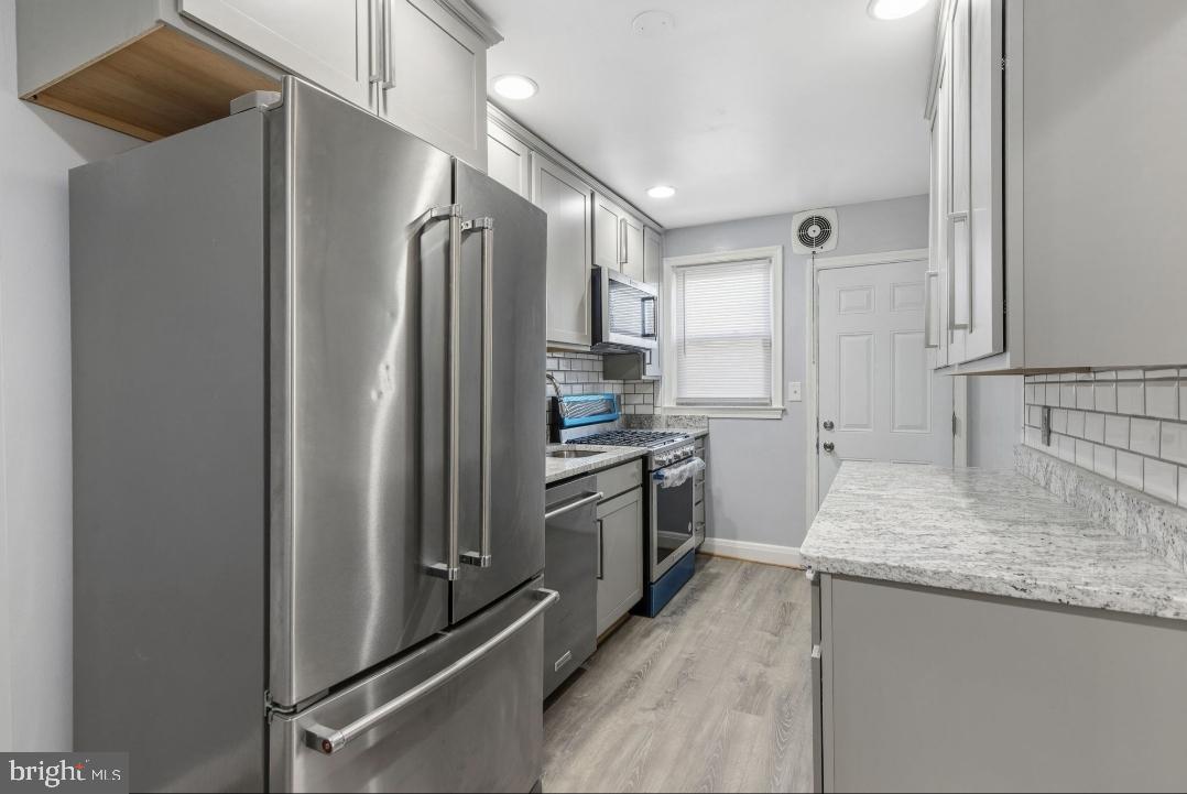 5102 Plymouth Road Baltimore, MD 21214 - Photo 8 of 32 a kitchen with stainless steel appliances granite countertop a refrigerator and a sink