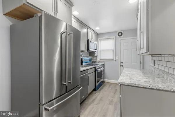 a kitchen with stainless steel appliances granite countertop a refrigerator and a sink