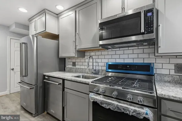 a kitchen with stainless steel appliances granite countertop a stove microwave and refrigerator