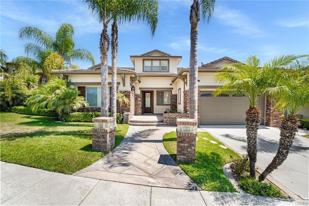 a front view of a house with garden and trees