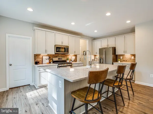 a kitchen with a table chairs refrigerator and microwave