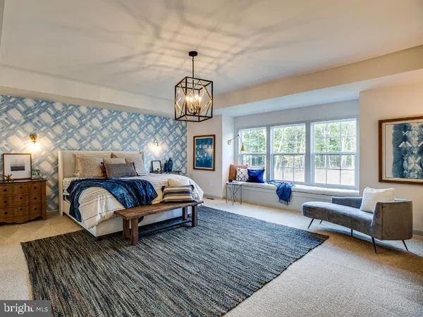 a spacious bedroom with a bed a couch and large window with couch