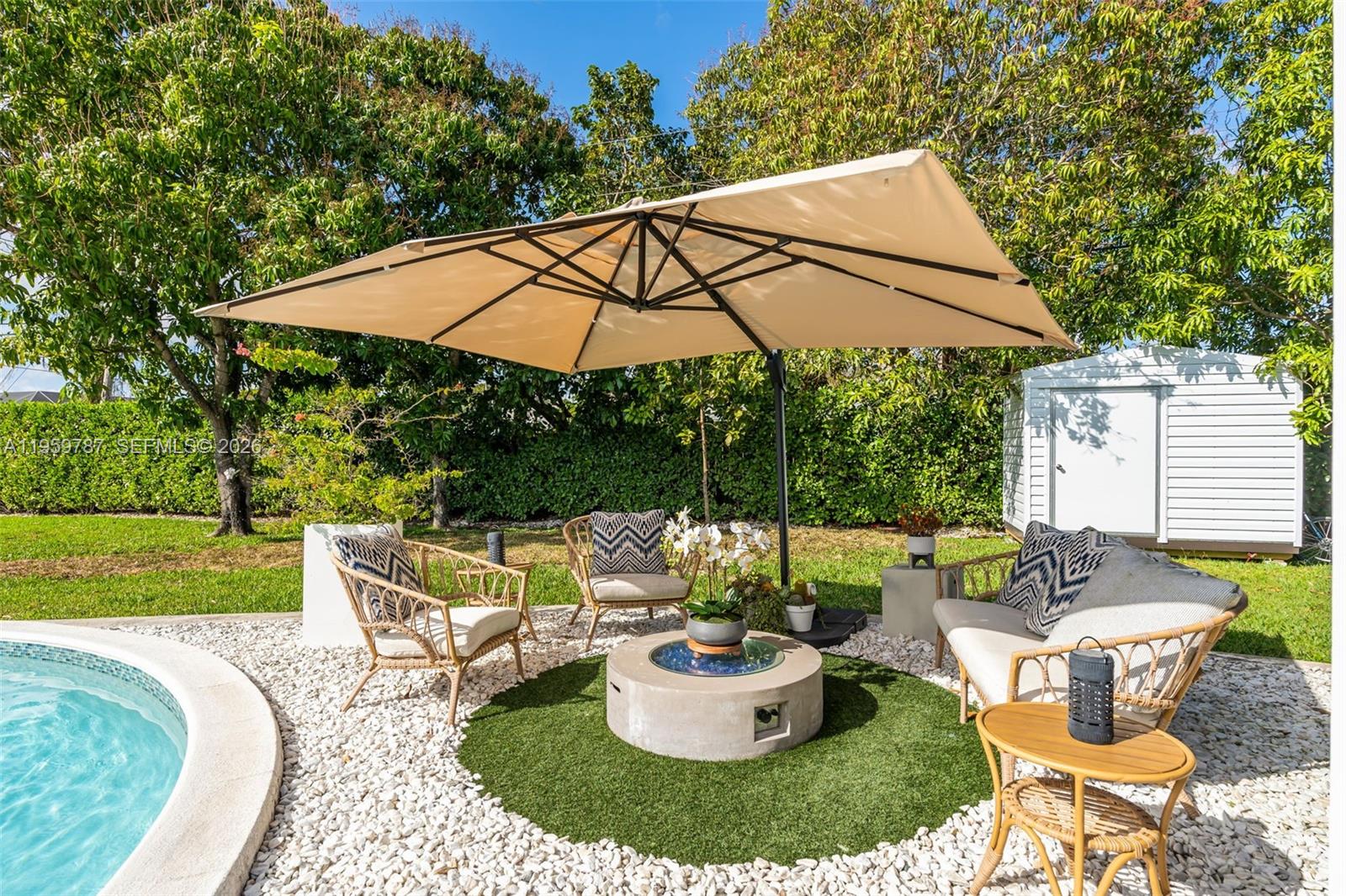 10971 Southwest 177th Street Miami, FL 33157 - Photo 27 of 41 a backyard of a house with table and chairs under an umbrella