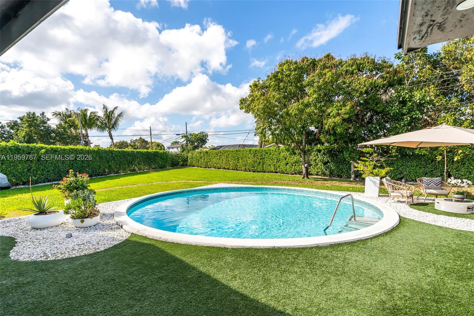 10971 Southwest 177th Street Miami, FL 33157 - Photo 29 of 41 a view of pool with lawn chairs and large trees
