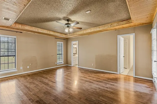 a view of an empty room with window and wooden floor