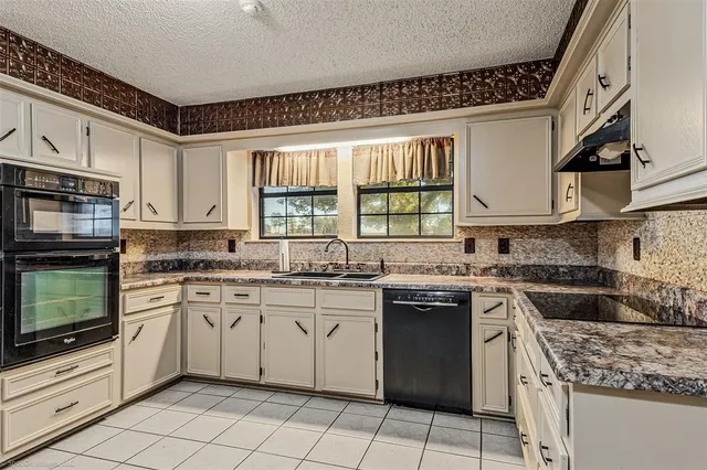 a kitchen with a stove sink and cabinets