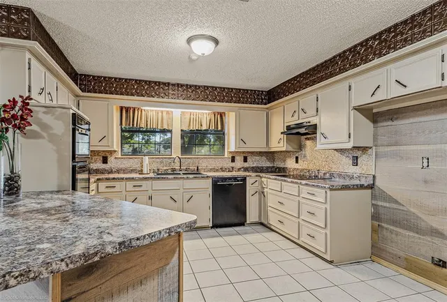 a kitchen with stainless steel appliances granite countertop a stove sink and cabinets