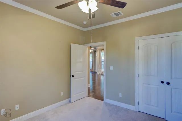 a view of a room with a chandelier fan and a bathroom