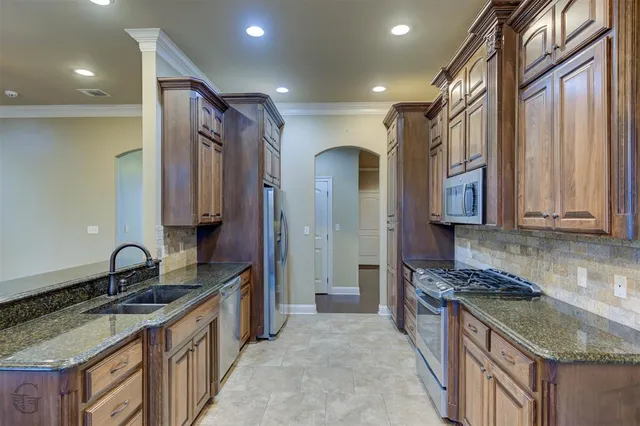 a kitchen with granite countertop a sink stove and cabinets