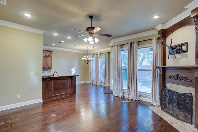 a view of a hallway with wooden floor and a kitchen