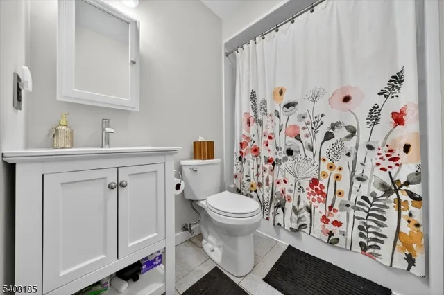 a bathroom with a toilet sink and shower curtain