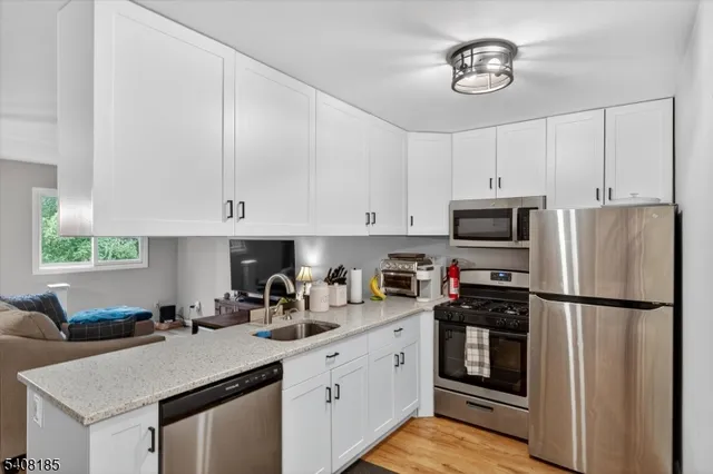 a kitchen with a refrigerator and white cabinets