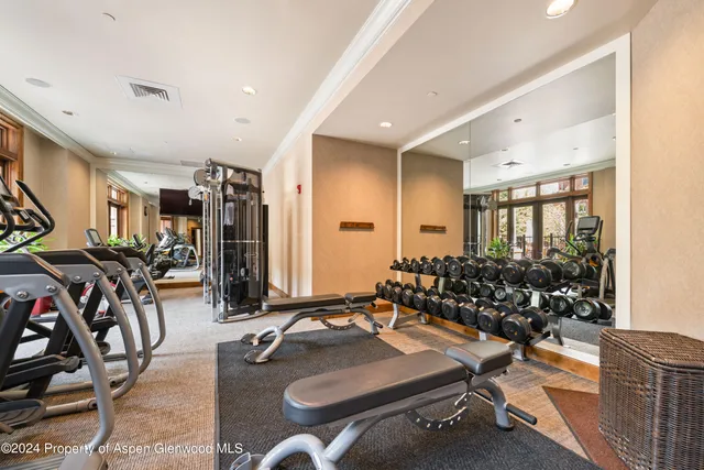 a room with gym equipment and large mirror