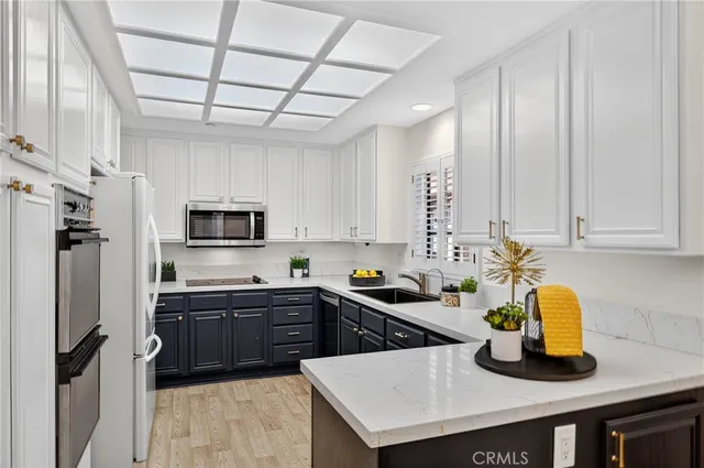 a kitchen with stainless steel appliances kitchen island granite countertop a refrigerator a stove a sink dishwasher and microwave with wooden floor