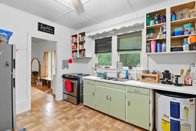 a kitchen with cabinets a window and stainless steel appliances