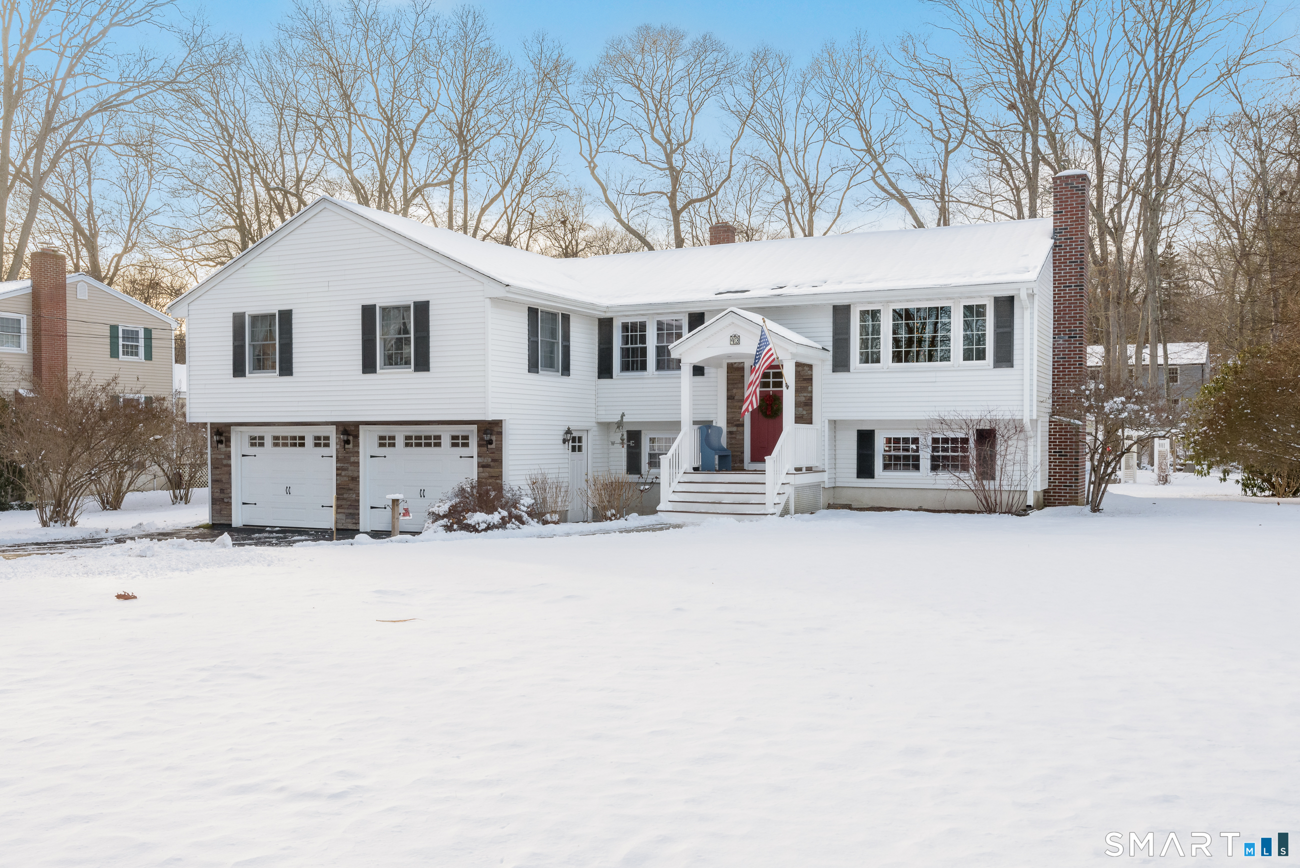 a view of a white house with a yard covered in snow