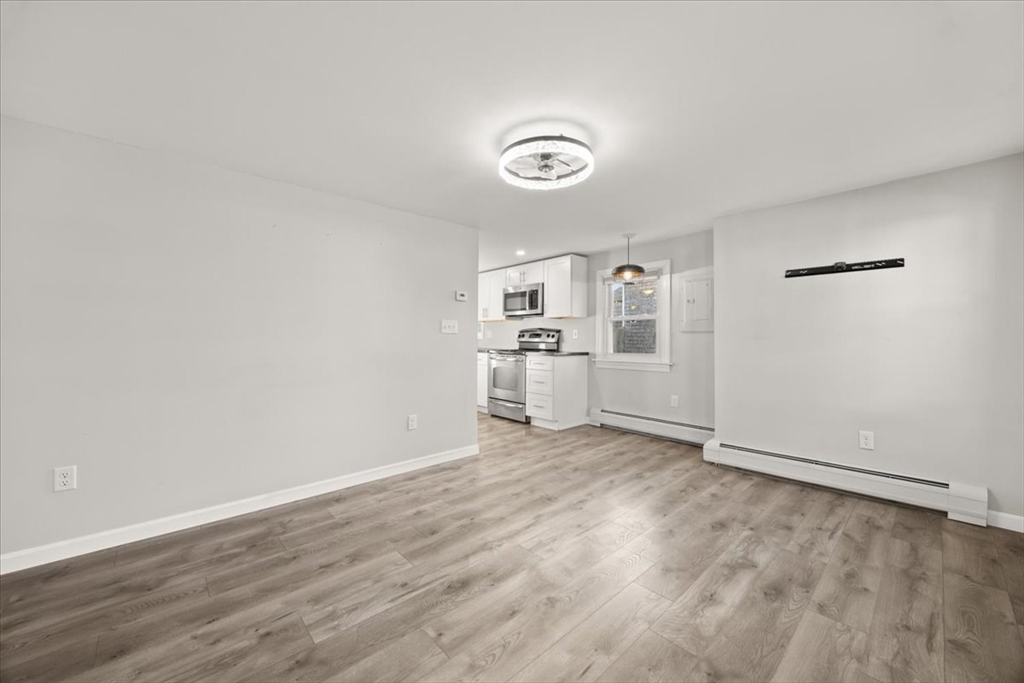 24 Harvard Street Fairhaven, MA 02719 - Photo 16 of 31 an empty room with wooden floor and white walls