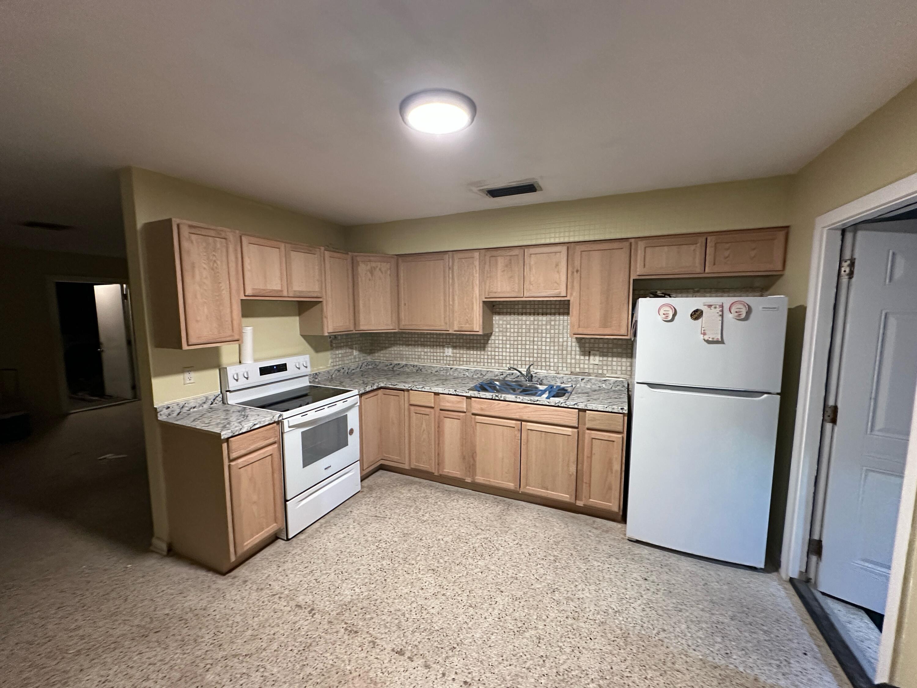 507 Silver Beach Road, Unit 506 Lake Park, FL 33403 - Photo 2 of 2 a kitchen with stainless steel appliances granite countertop a refrigerator a stove top oven a sink and dishwasher