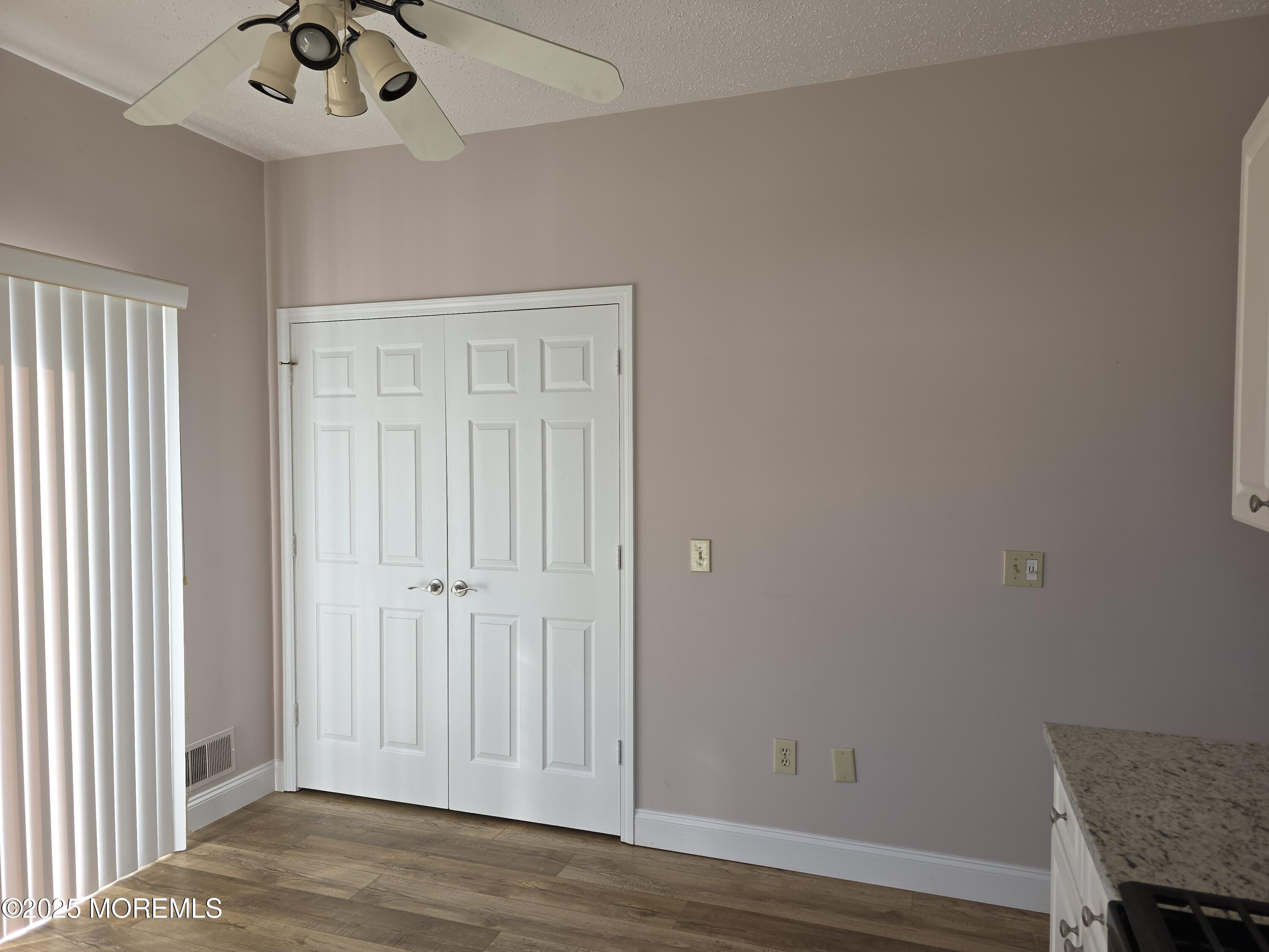 61 Sandpiper Road Barnegat, NJ 08005 - Photo 11 of 44 an empty room with a door and wooden floor