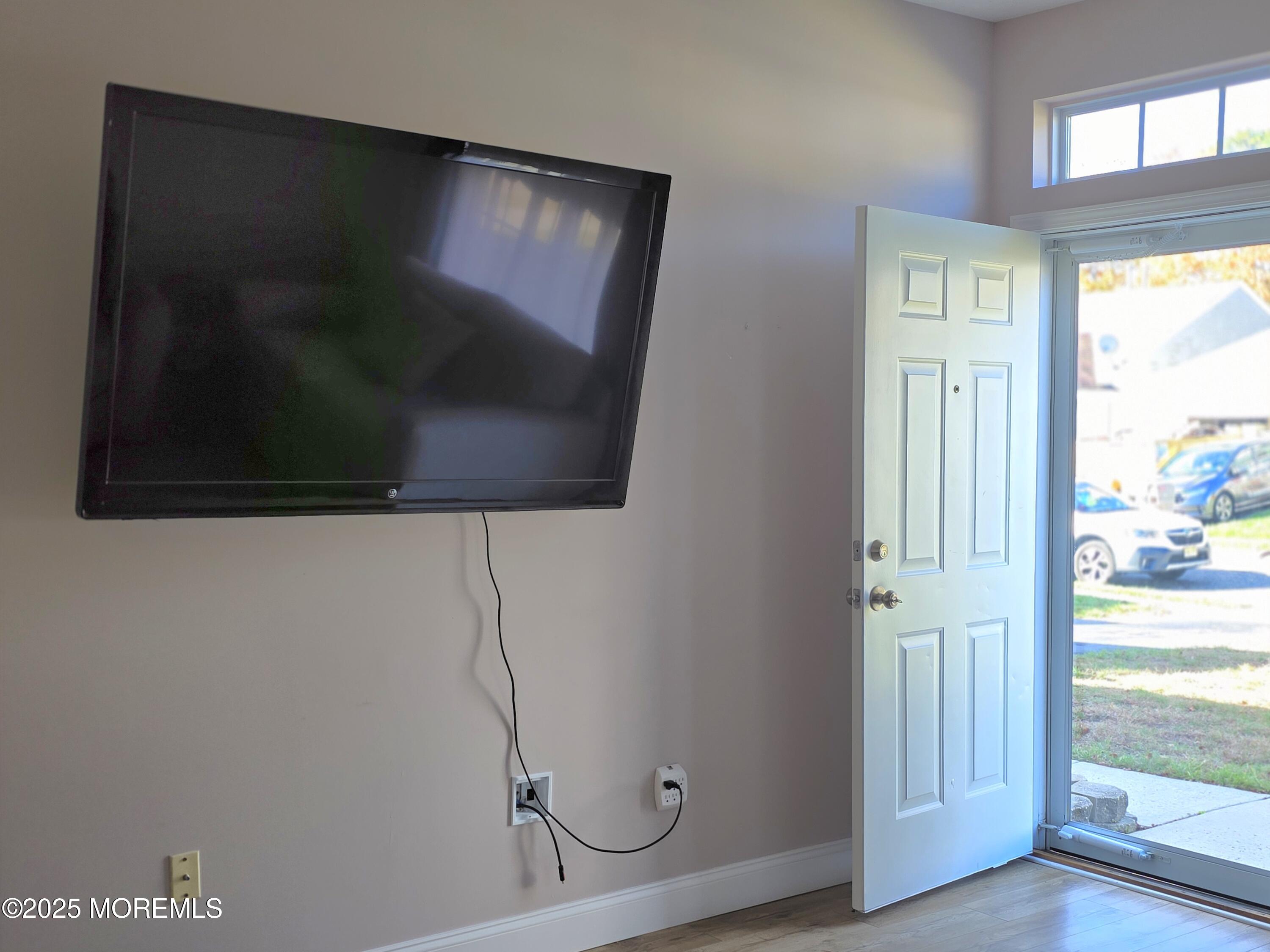 61 Sandpiper Road Barnegat, NJ 08005 - Photo 19 of 44 a living room with a flat screen tv and a floor to ceiling window
