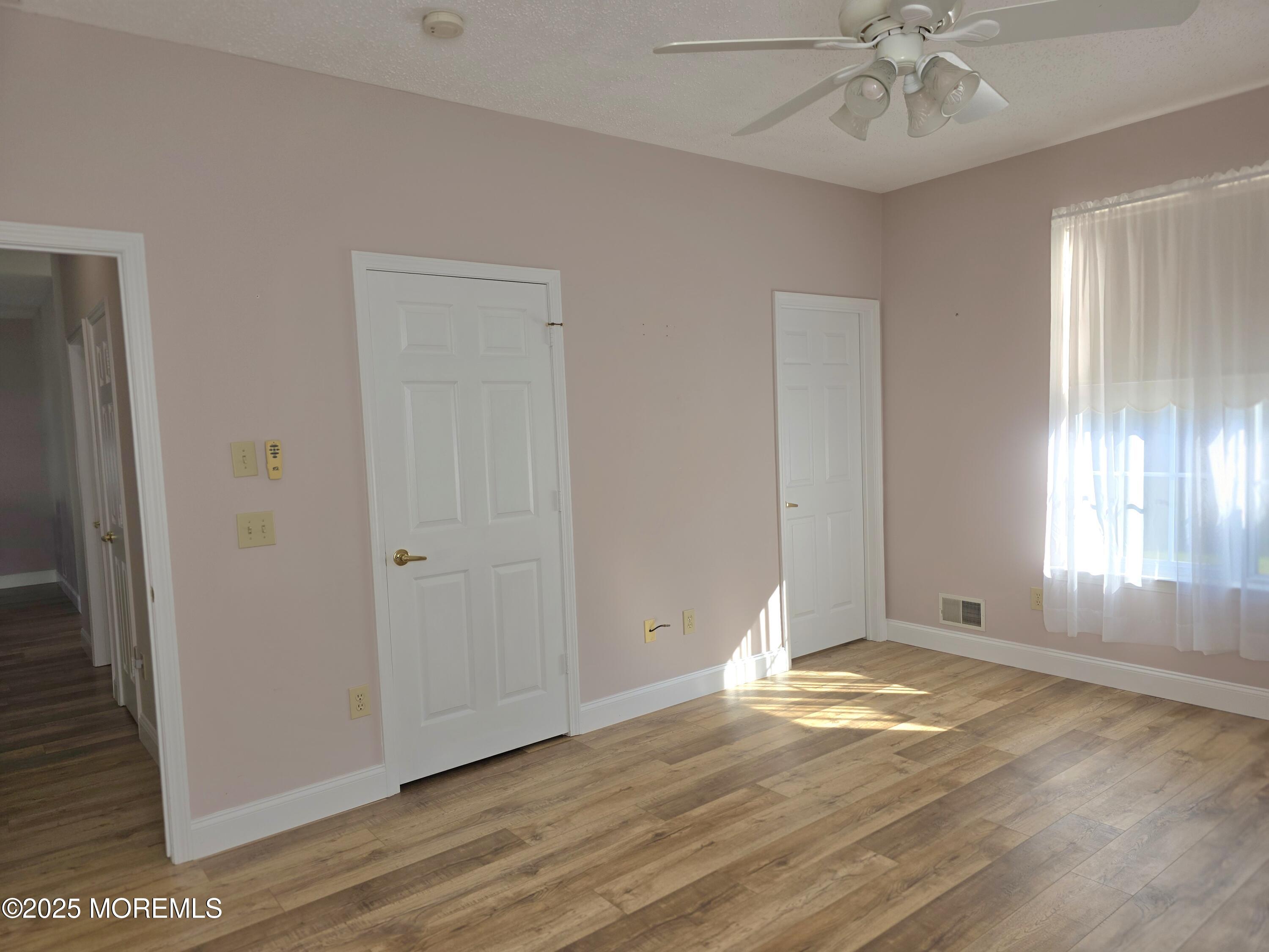 61 Sandpiper Road Barnegat, NJ 08005 - Photo 30 of 44 an empty room with wooden floor and windows
