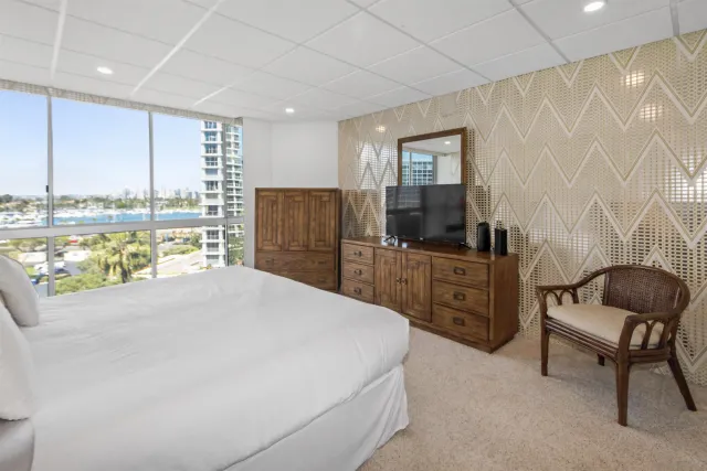 a room with a bed a chair and glass door