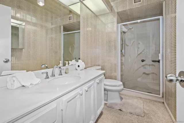 a bathroom with a double vanity sink toilet and shower
