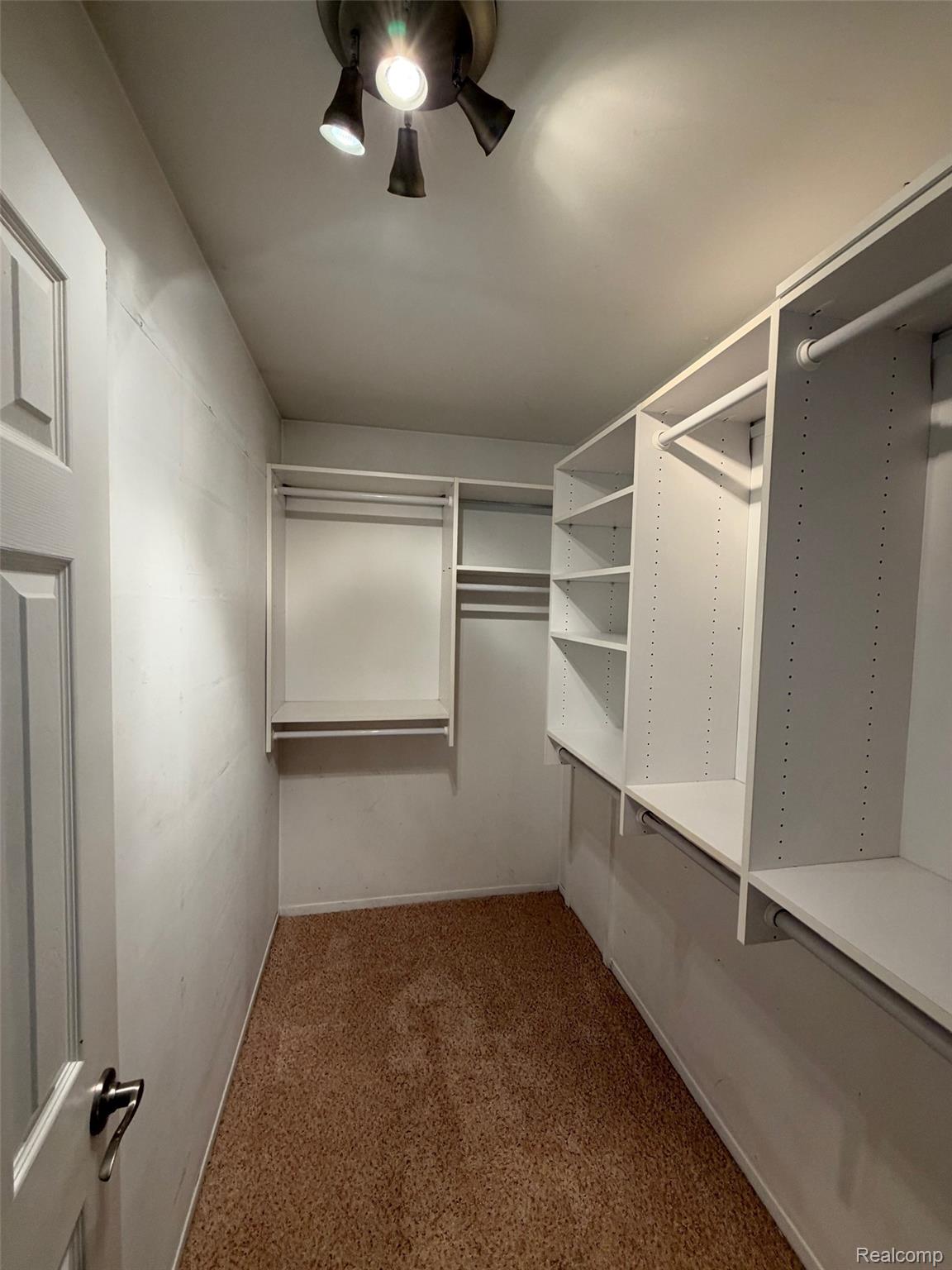 24525 Jamestowne Road Novi, MI 48375 - Photo 16 of 20 Walk-in closet featuring built-in white shelving, hanging rods, and track lighting