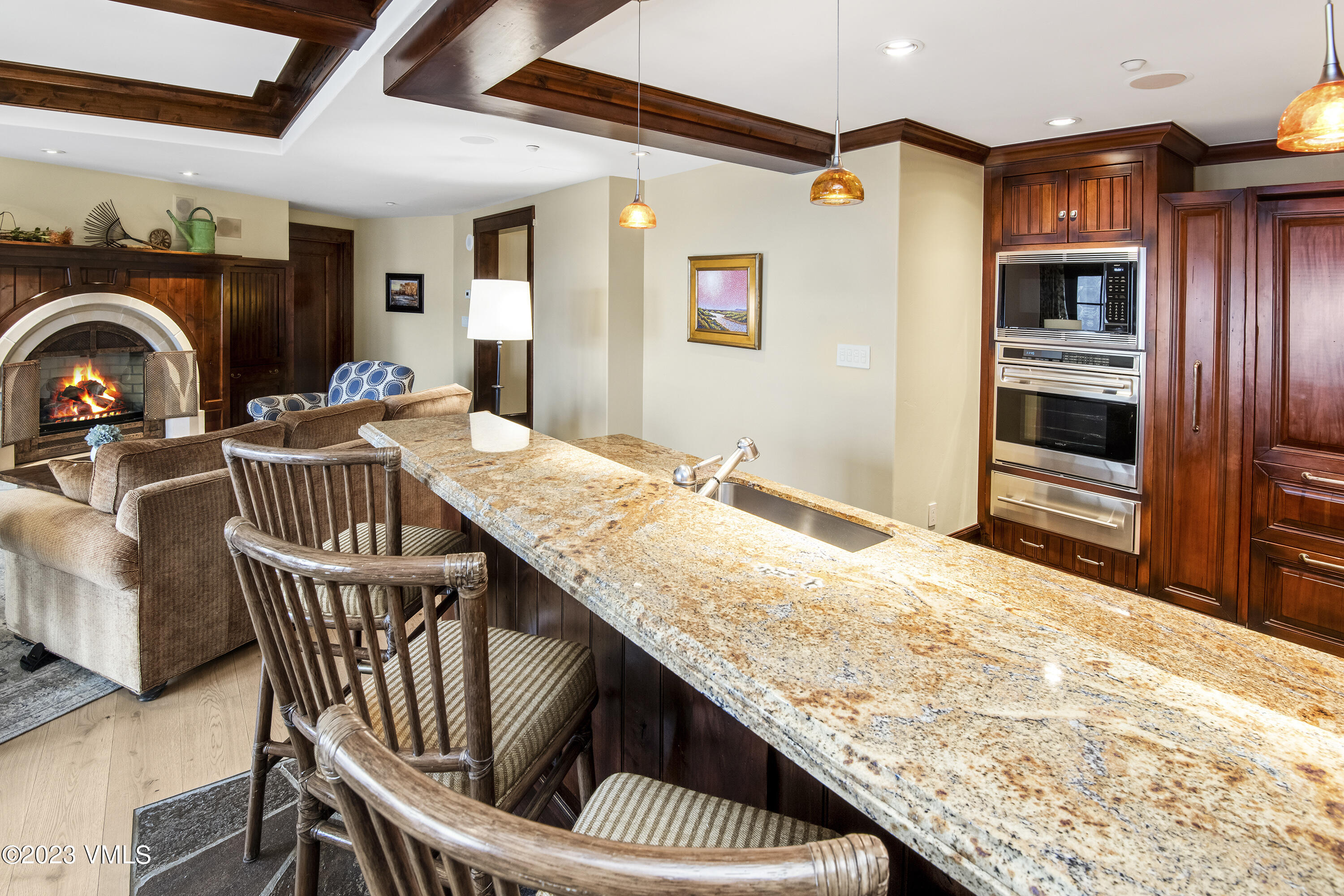 1 Willow Bridge Road, Unit 31A Vail, CO 81657 - Photo 8 of 49 a kitchen with granite countertop a stove a oven a dining table and chairs with wooden floor