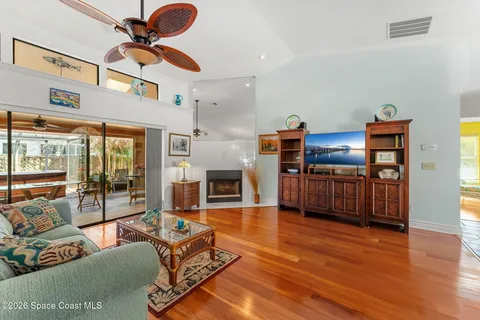 a living room with furniture a wooden floor and a chandelier