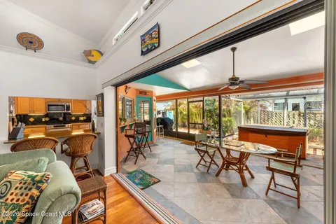 a living room with patio furniture and floor to ceiling window