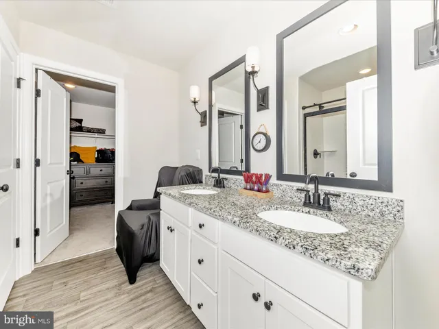 a en suite bathroom with a granite countertop sink and a mirror