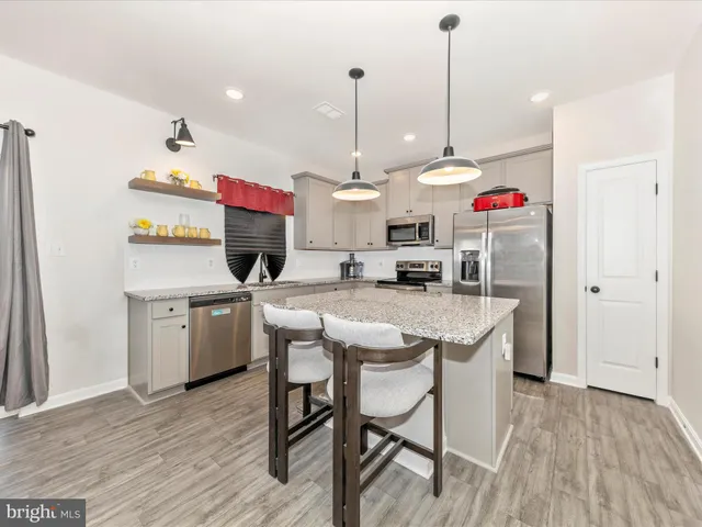 a kitchen with stainless steel appliances granite countertop a stove and white cabinets