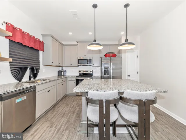 a kitchen with a dining table chairs sink and cabinets