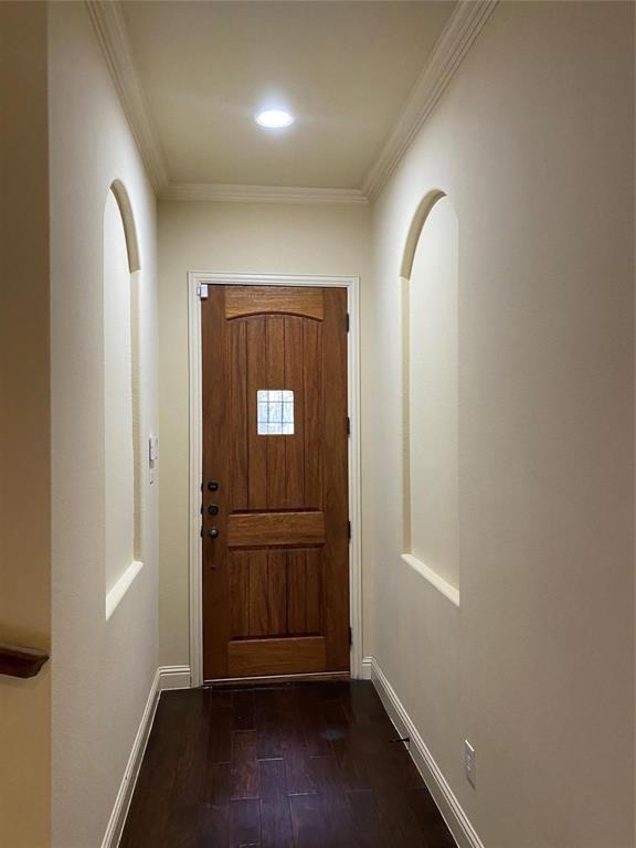 2222 Kirby Street Dallas, TX 75204 - Photo 25 of 25 Entryway featuring a rich wood-paneled door with an inset window, dark wood-finish flooring, two arched wall alcoves, crown molding, and recessed lighting