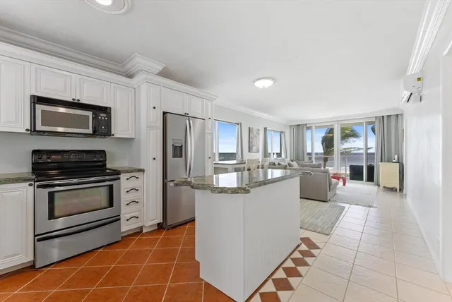 a kitchen with stainless steel appliances granite countertop a stove a sink and a microwave