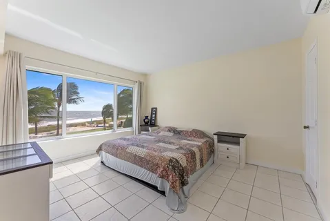 a spacious bedroom with a bed and a dresser next to a window