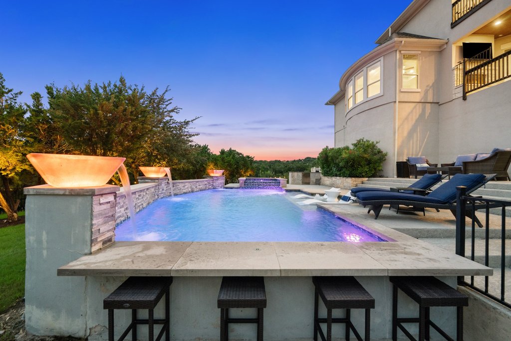 215 Lodestone Lane Austin, TX 78738 - Photo 36 of 40 An inviting backyard oasis offers a sparkling pool with water features and integrated bar seating.