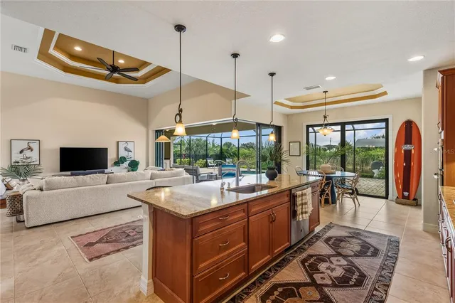 a kitchen with a sink a counter top space appliances and a chandelier