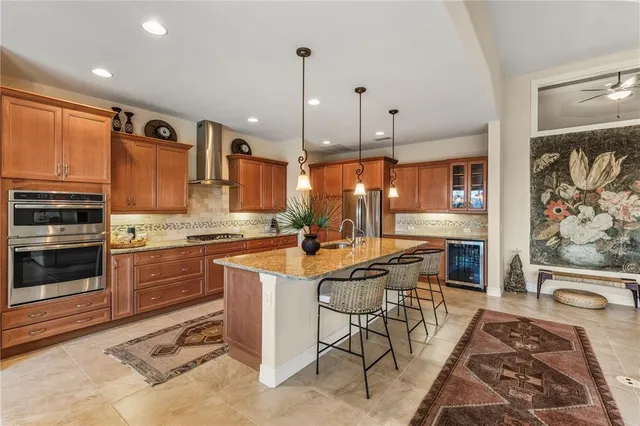 a kitchen with stainless steel appliances granite countertop a stove a sink and a refrigerator