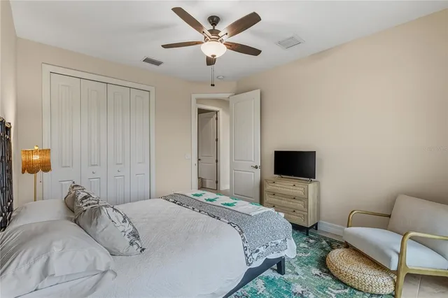 a bedroom with a bed couch and a flat screen tv