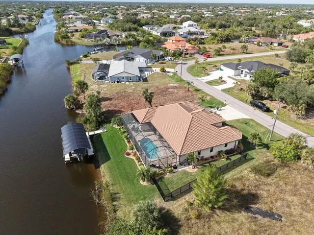 an aerial view of a house with a yard and lake view
