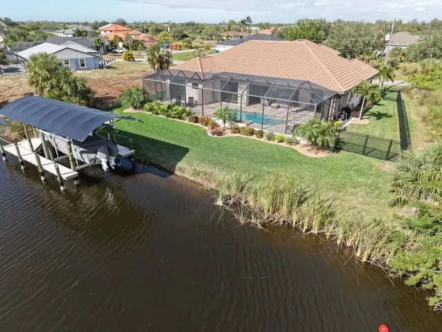 an aerial view of a house with a garden and lake view